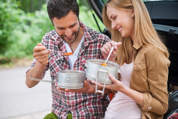 Casal comendo no carro antes de fazer uma caminhada