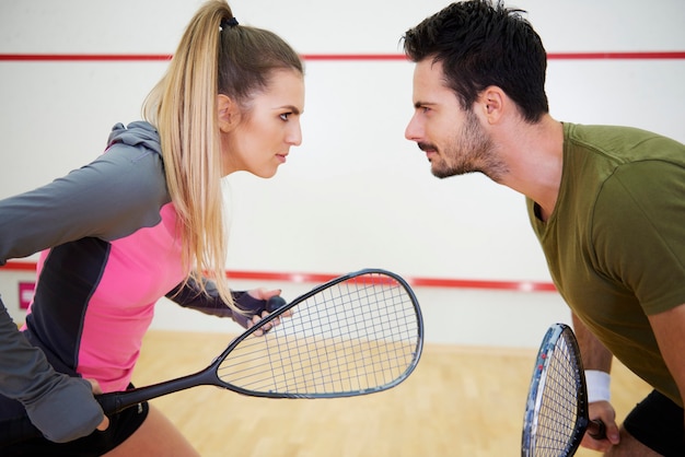 Casal competitivo jogando squash