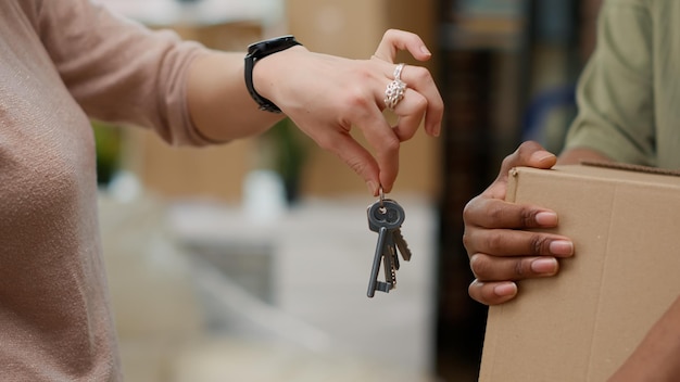 Casal comprando a primeira casa e tendo as chaves da casa, movendo-se juntos em imóveis. Celebrando o evento de relacionamento e a realocação da casa comprada com hipoteca. Fechar-se.