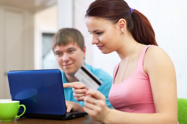 Casal comprando online com laptop e cartão de crédito