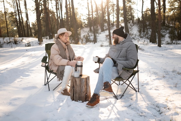 Foto grátis casal curtindo seu acampamento de inverno