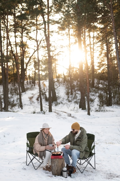 Casal curtindo seu acampamento de inverno