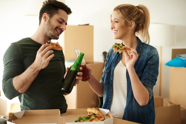 Foto grátis casal curtindo um drinque e pizza para viagem