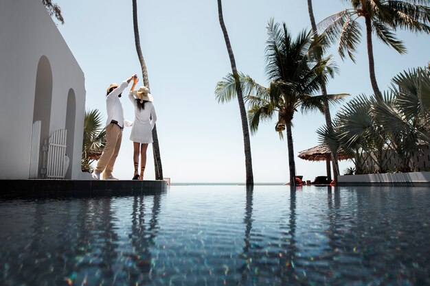 Casal dançando na piscina durante as férias