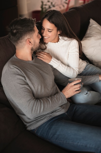 Foto grátis casal de alto ângulo no jovem casal sorridente no sofá