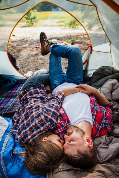 Casal de alto ângulo relaxante na barraca