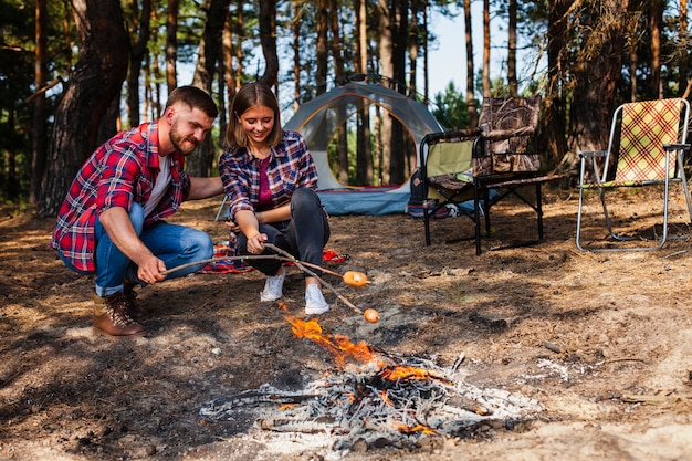 Foto grátis casal de baixo ângulo, acampar e cozinhar