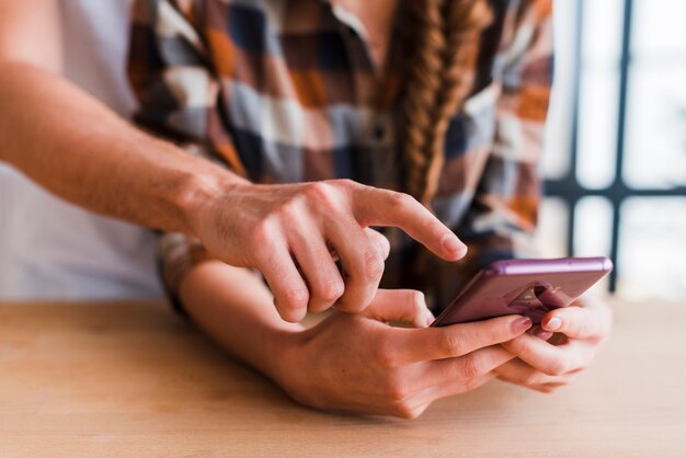 Casal de colheita usando smartphone juntos