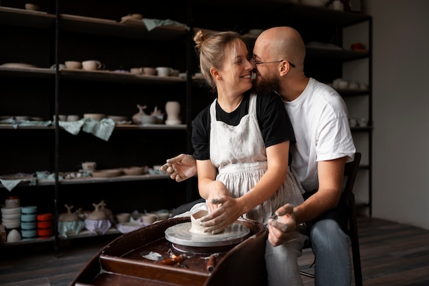 Foto grátis casal de escultores trabalhando juntos com argila no estúdio