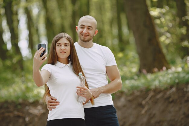 Casal de esporte passa o tempo em uma floresta de verão