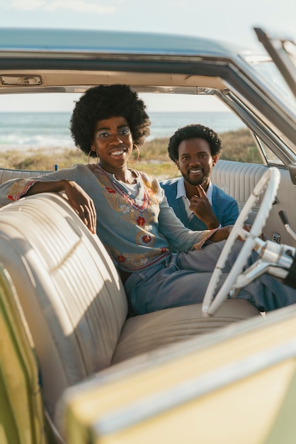 Foto grátis casal de estilo retrô aguardando o tempo à beira-mar