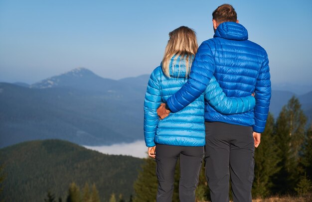 Casal de família admirando belas paisagens montanhosas