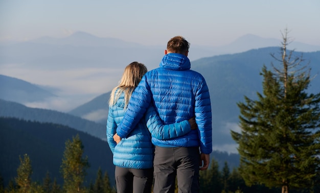 Casal de família admirando belas paisagens montanhosas