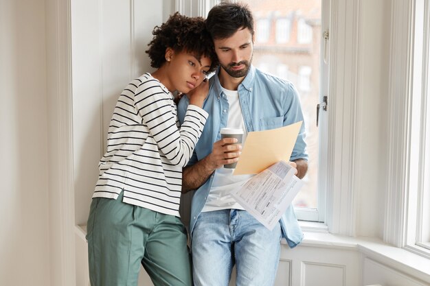 Casal de família de raça mista tem problemas, tem expressões de frustração, pensa em como resolver problemas.