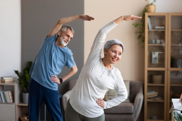 Casal de idosos fazendo exercícios em casa