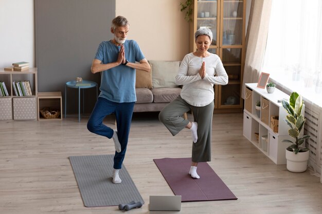 Casal de idosos fazendo exercícios em casa