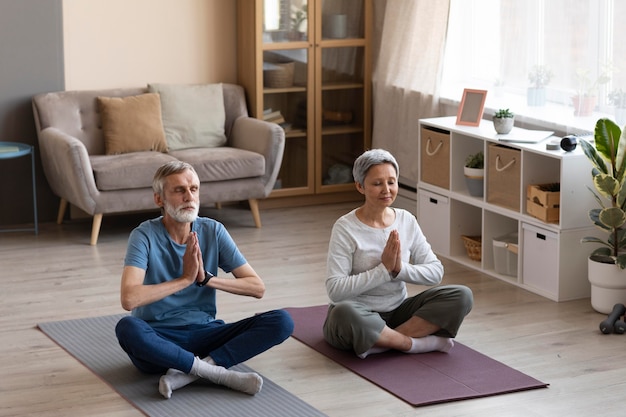 Foto grátis casal de idosos fazendo exercícios juntos em casa