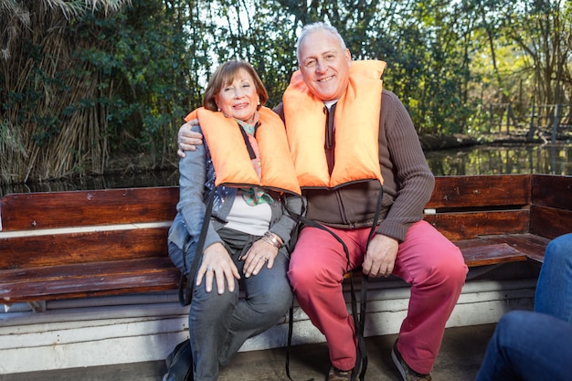 casal de idosos sentado em um banco de madeira
