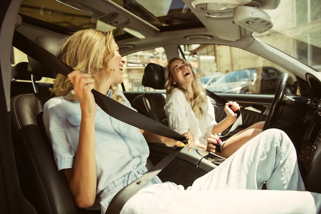 Casal de jovens lésbicas se preparando para uma viagem de férias no carro em um dia ensolarado