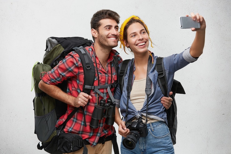 Foto grátis casal de jovens turistas com equipamento