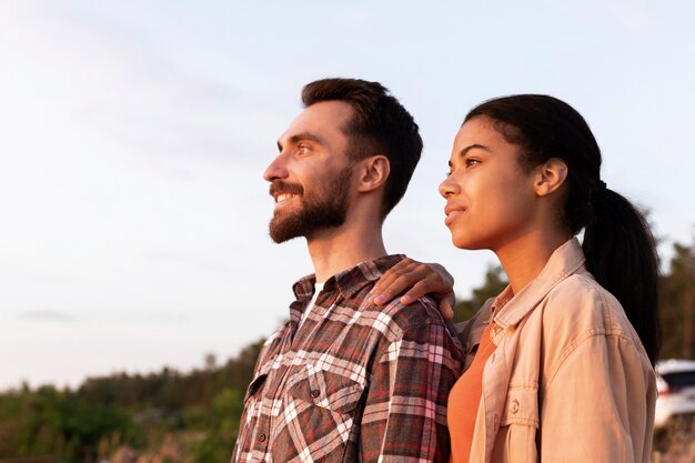 Casal de lado vendo o pôr do sol