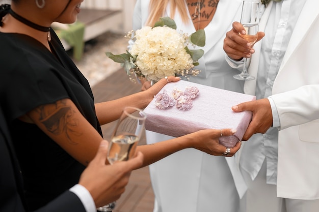 Foto grátis casal de lésbicas aceitando presentes de convidados em seu casamento