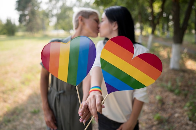 Casal de lésbicas com bandeira lgbt em formato de coração