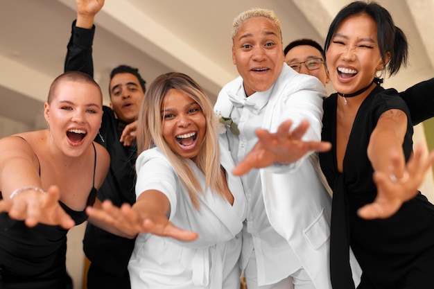 Foto grátis casal de lésbicas com convidados em seu casamento