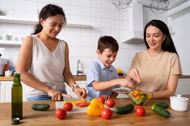 Casal de lésbicas com o filho preparando comida