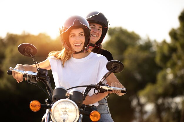 Casal de lésbicas em uma motocicleta com capacetes