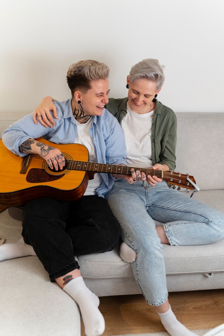 Foto grátis casal de lésbicas romântico de tiro completo com guitarra
