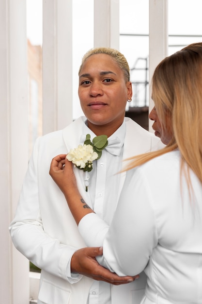 Foto grátis casal de lésbicas vestindo branco durante o casamento