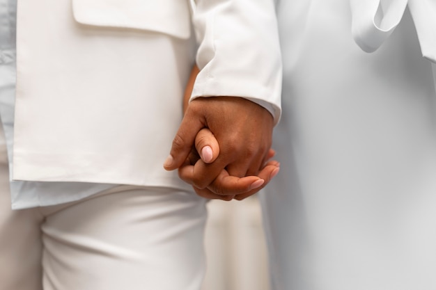 Foto grátis casal de lésbicas vestindo branco durante o casamento