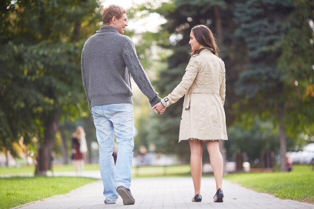 Casal de mãos dadas caminhando para longe