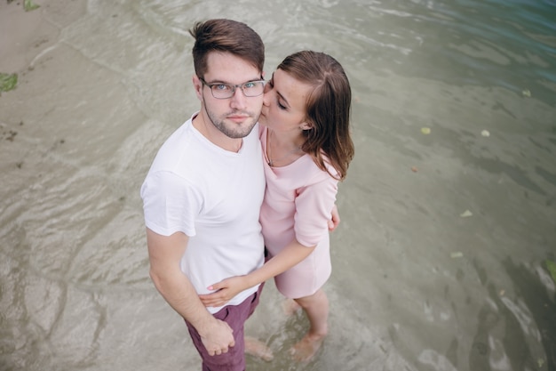 Casal de mãos dadas com os pés na água