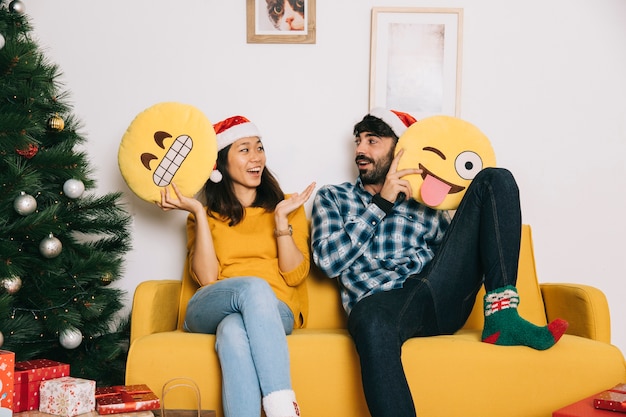 Casal de Natal no sofá com emoticons