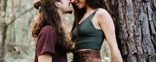 Casal de pedestrianismo apaixonado beijando na natureza