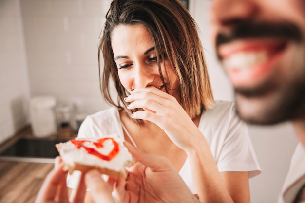 Foto grátis casal de rir comendo torradas deliciosas