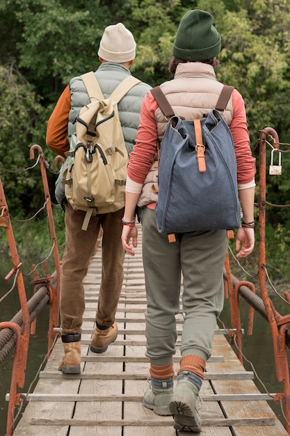 Casal de tiro completo caminhando na ponte de madeira