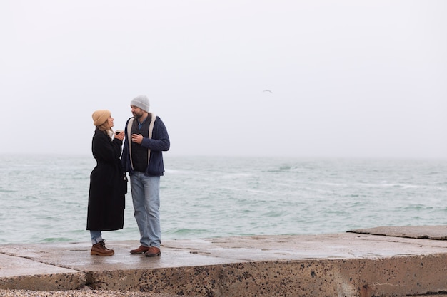 Foto grátis casal de tiro completo passando um tempo à beira-mar