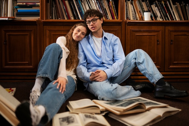 Foto grátis casal de tiro completo tendo um encontro na livraria