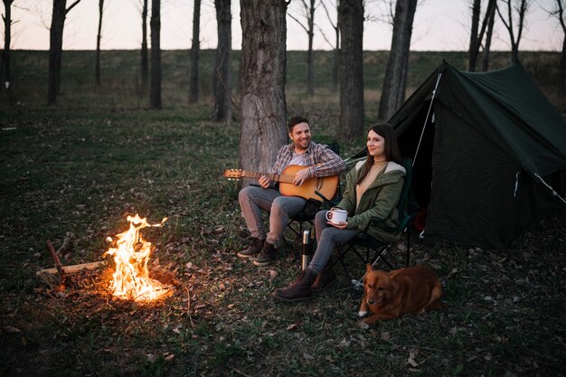 Casal de tiro completo tocando violão