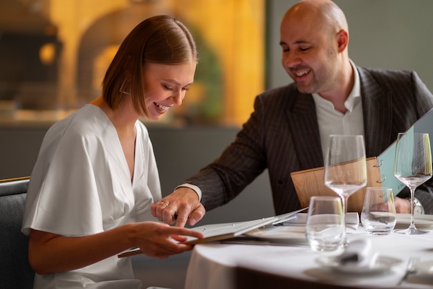 Casal de tiro médio almoçando em restaurante de luxo