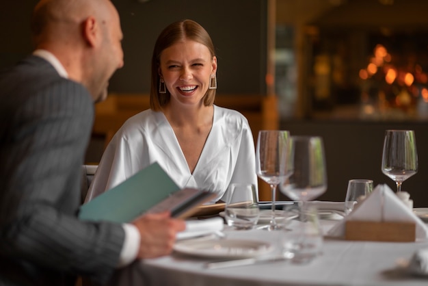 Foto grátis casal de tiro médio almoçando em restaurante de luxo