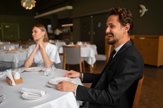 Foto grátis casal de tiro médio almoçando em restaurante de luxo