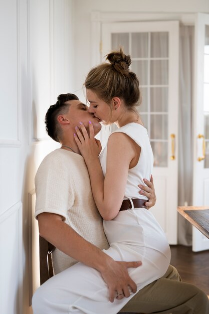 Casal de tiro médio beijando em casa