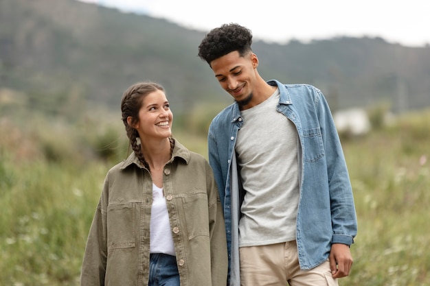 Casal de tiro médio caminhando ao ar livre