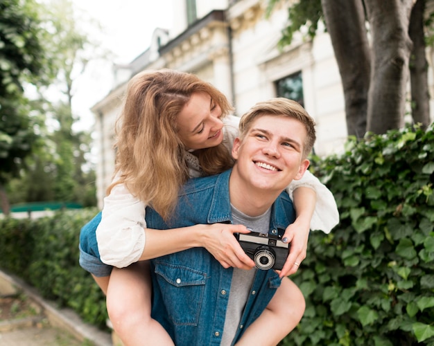 Casal de tiro médio com câmera posando