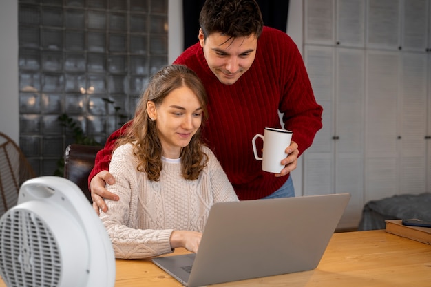 Foto grátis casal de tiro médio com laptop em casa