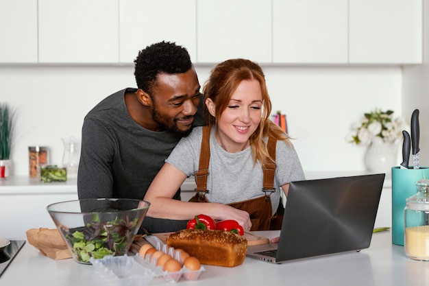 Casal de tiro médio com laptop